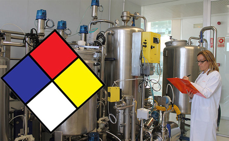Científica revisando equipo industrial y el logo de grado de riesgo. Rombo formado por 4 rombos, de los colores azul, rojo, amarillo, blanco